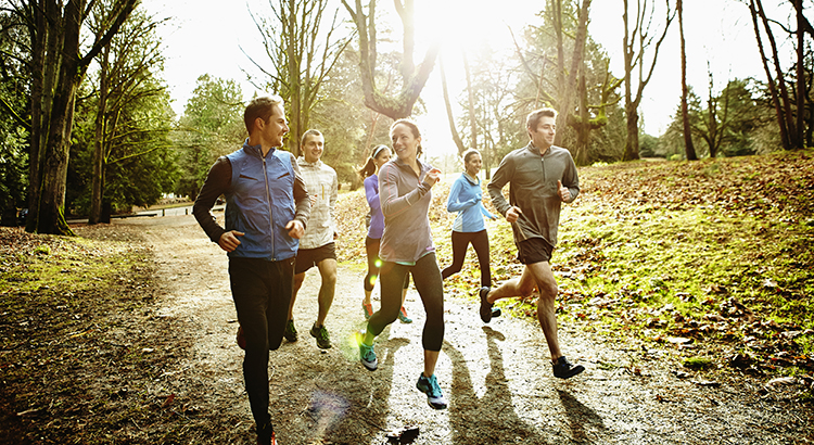 Smiling friends running together in park